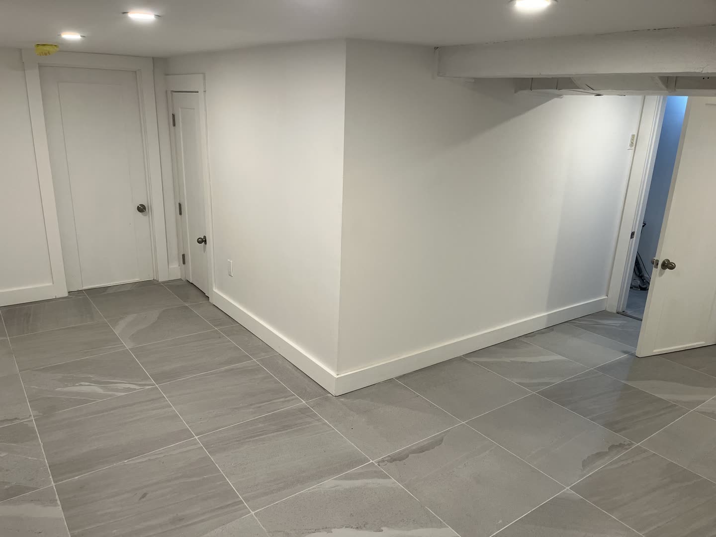 Finished basement renovation with grey tile floor