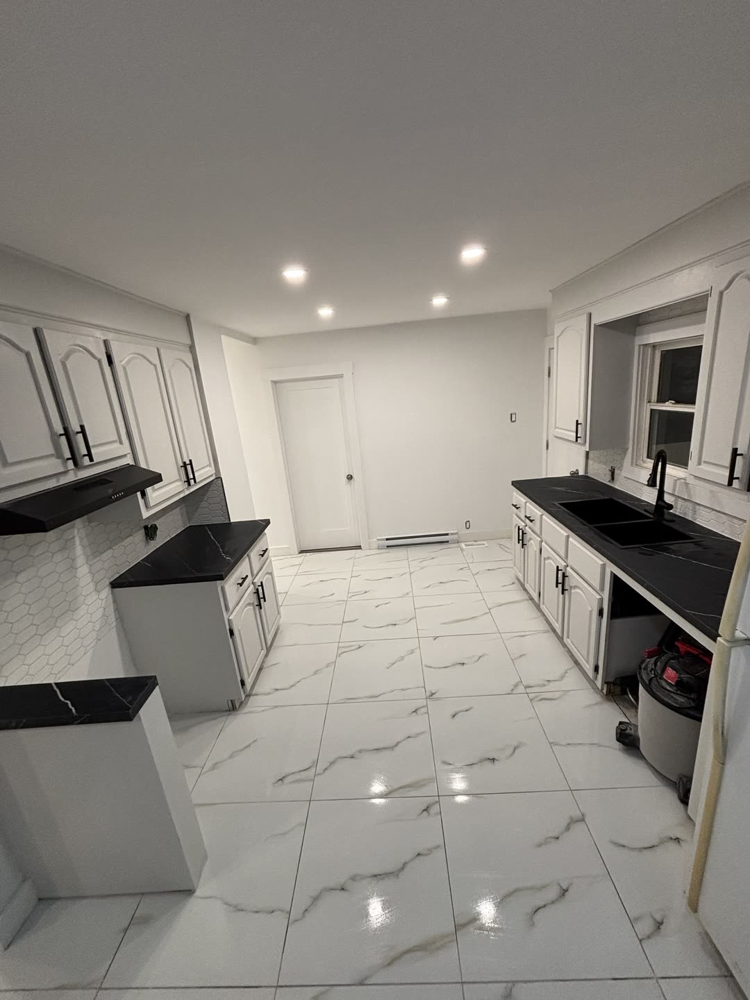 White-cabinet kitchen with soapstone counters and hex tile backsplash